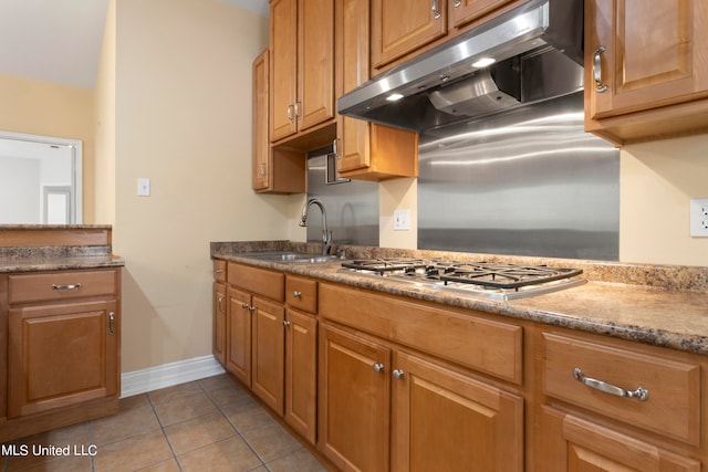 kitchen with light tile patterned floors, sink, and stainless steel gas stovetop