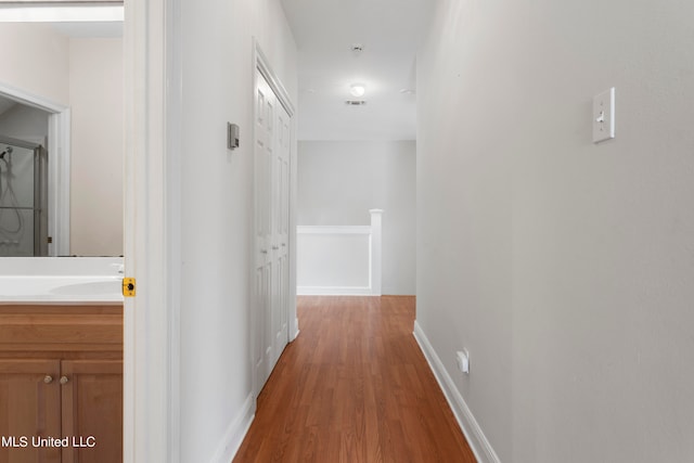 hallway featuring sink and hardwood / wood-style floors