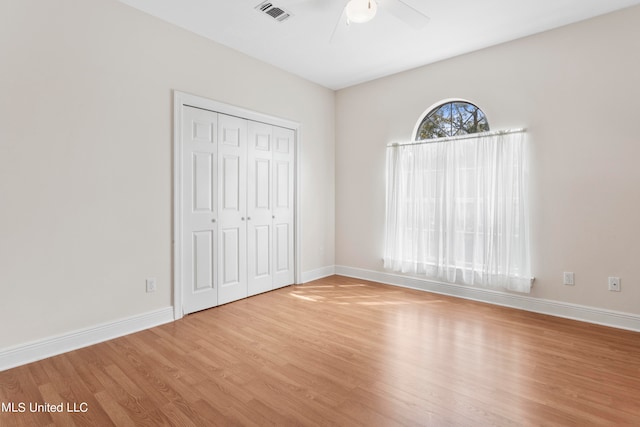 unfurnished bedroom featuring a closet, light wood-type flooring, and ceiling fan