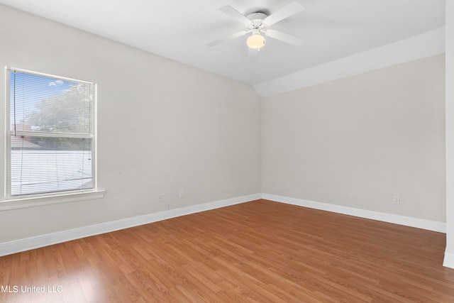 spare room featuring wood-type flooring, vaulted ceiling, and ceiling fan