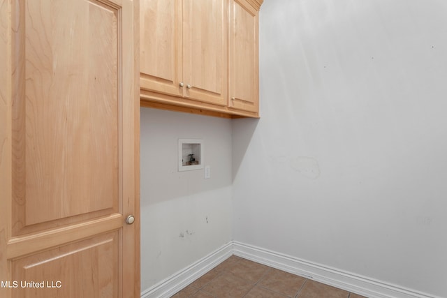 laundry area featuring dark tile patterned flooring, cabinets, and hookup for a washing machine