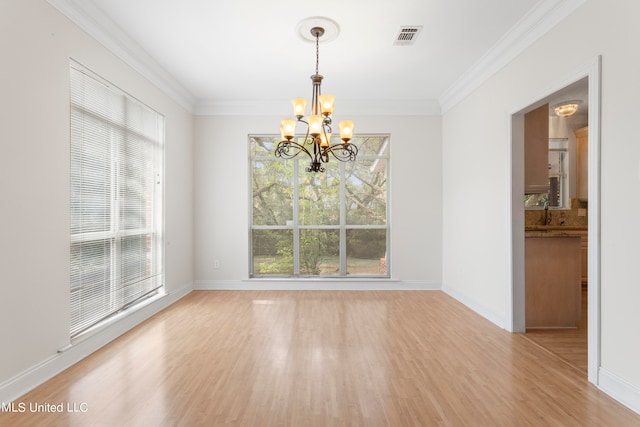 unfurnished dining area featuring ornamental molding, light hardwood / wood-style flooring, and a notable chandelier