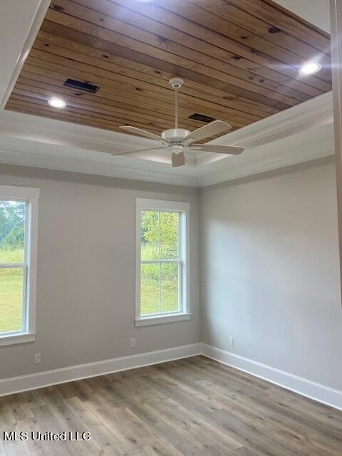 spare room featuring hardwood / wood-style floors, ceiling fan, wooden ceiling, and plenty of natural light