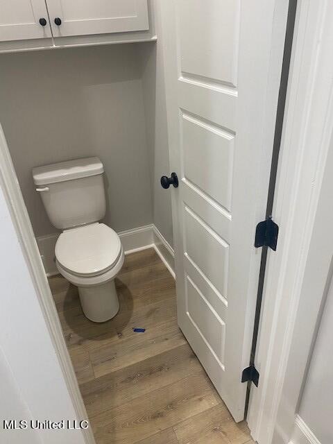 bathroom with toilet and hardwood / wood-style flooring