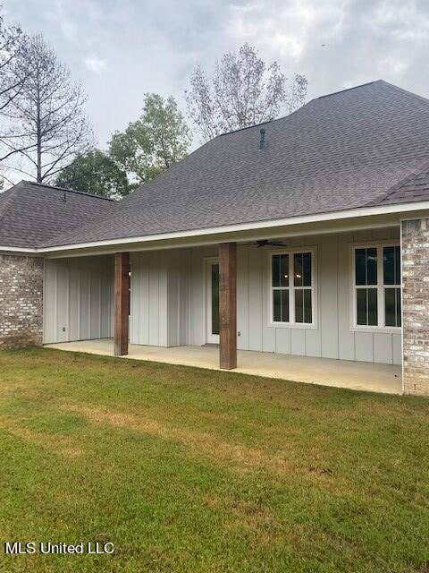 back of property featuring a yard, a patio area, and ceiling fan