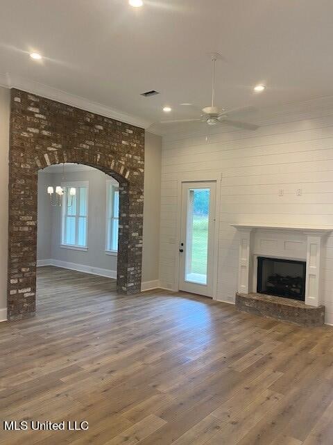 unfurnished living room featuring ornamental molding, hardwood / wood-style floors, and ceiling fan with notable chandelier