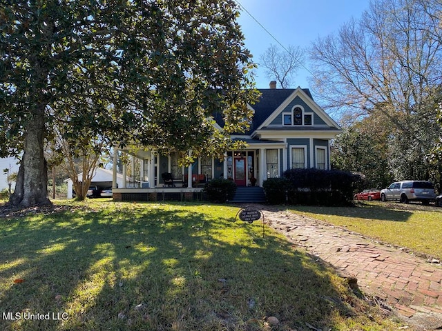 view of front of property with a chimney and a front lawn