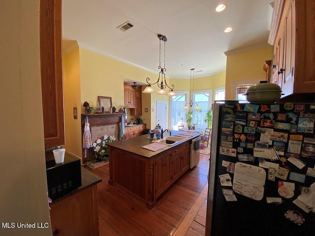 kitchen featuring a center island with sink, visible vents, hardwood / wood-style floors, stainless steel appliances, and crown molding