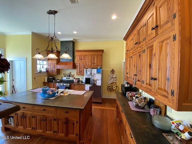 kitchen with dark countertops, brown cabinetry, premium range hood, and stainless steel appliances