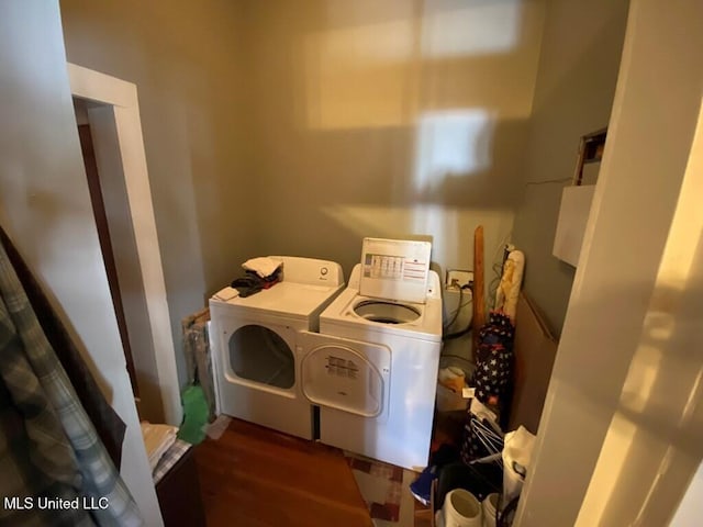 clothes washing area featuring separate washer and dryer and wood finished floors