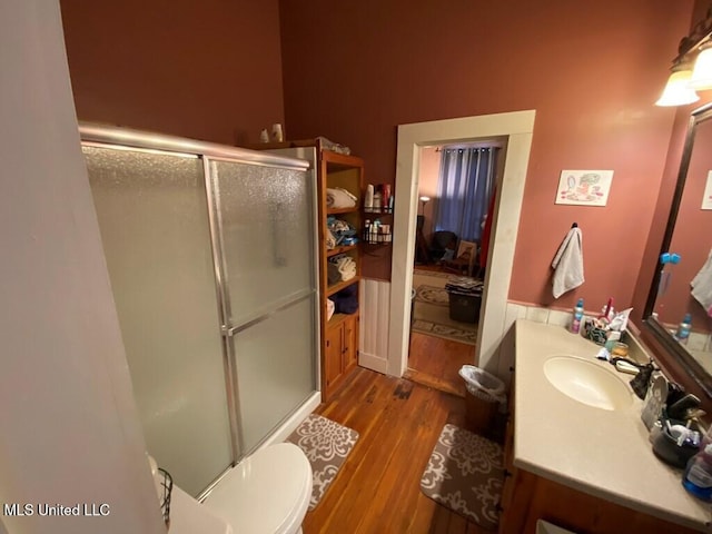 bathroom featuring a stall shower, vanity, toilet, and wood finished floors