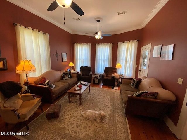 living area featuring visible vents, crown molding, and wood finished floors