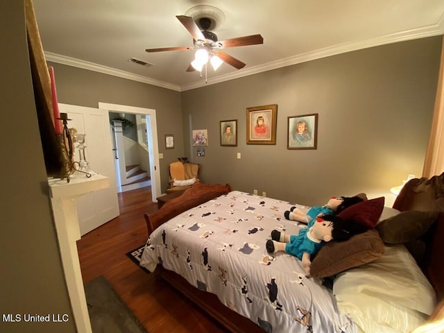 bedroom with visible vents, ornamental molding, ceiling fan, and hardwood / wood-style floors