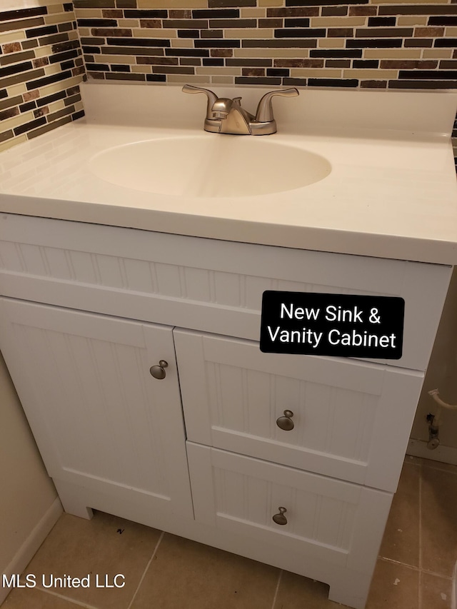 bathroom with decorative backsplash, baseboards, vanity, and tile patterned floors