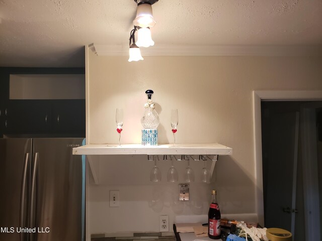 kitchen featuring freestanding refrigerator and a textured ceiling