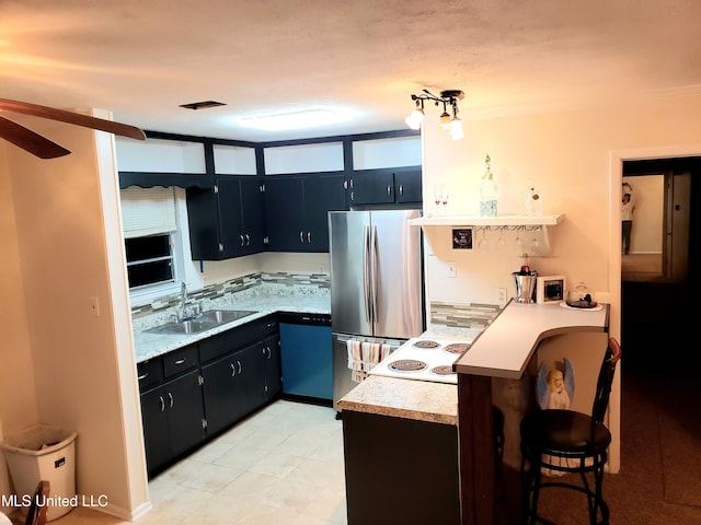 kitchen featuring light countertops, dishwasher, a ceiling fan, a sink, and freestanding refrigerator