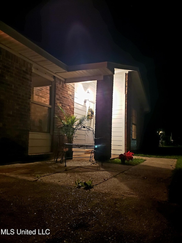 property exterior at twilight featuring brick siding