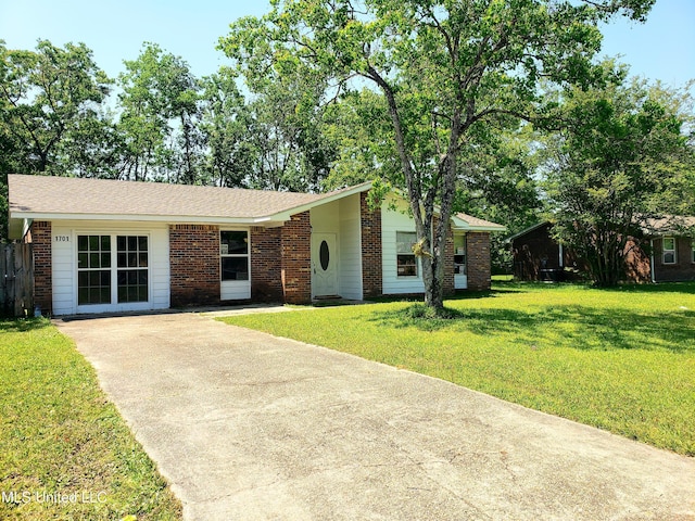ranch-style home with brick siding, driveway, and a front yard