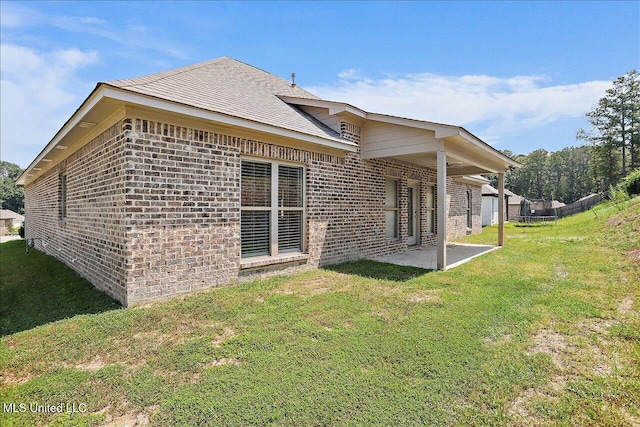 rear view of property featuring a yard and a patio area