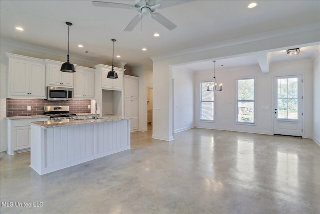 kitchen with white cabinets, ornamental molding, a kitchen island with sink, light stone counters, and stainless steel appliances