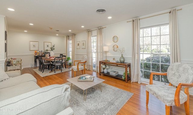 living room with recessed lighting, wood finished floors, visible vents, and a healthy amount of sunlight