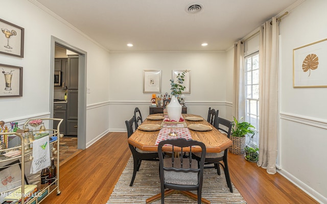 dining area with recessed lighting, wood finished floors, visible vents, and crown molding