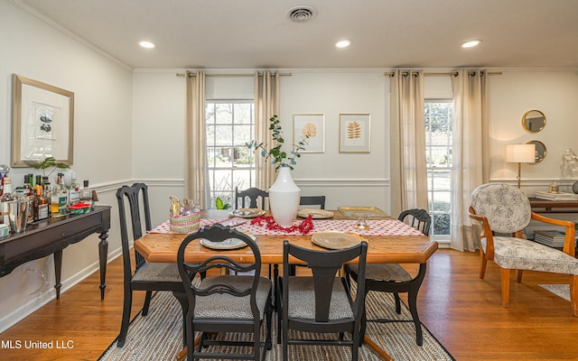 dining area featuring crown molding, visible vents, and wood finished floors