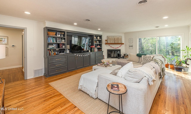 living area featuring light wood-type flooring, visible vents, and recessed lighting