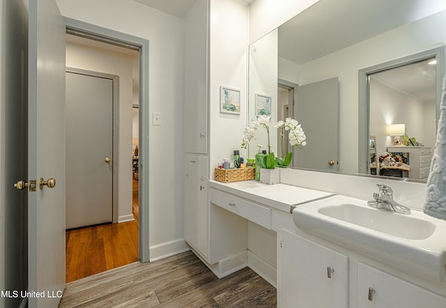 bathroom featuring wood finished floors, vanity, and baseboards