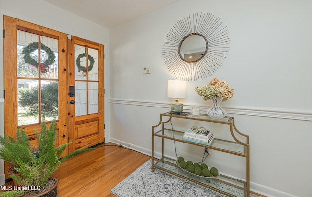 foyer entrance featuring french doors, wood finished floors, and baseboards