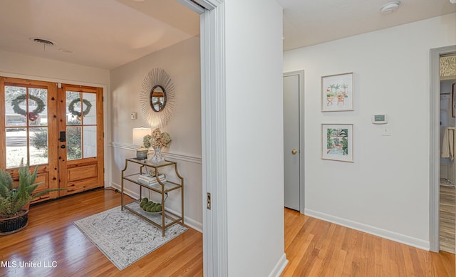 foyer entrance featuring french doors, wood finished floors, visible vents, and baseboards