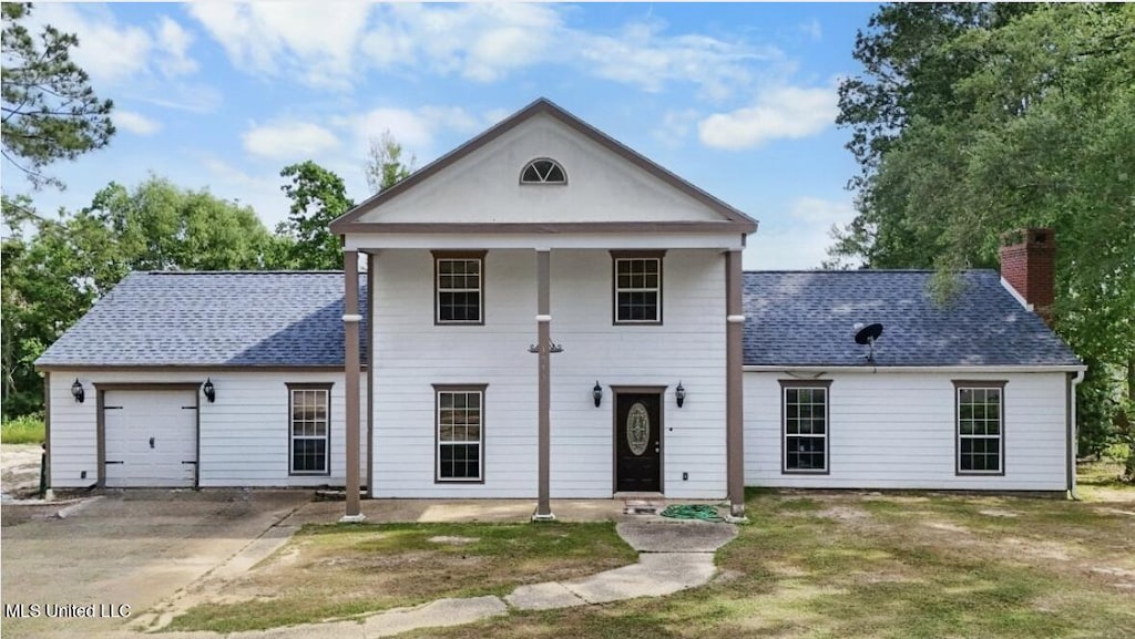 1975 Bayside Dr, Biloxi, MS 39532 - greek revival house featuring a shingled roof, concrete driveway, a chimney, and an attached garage