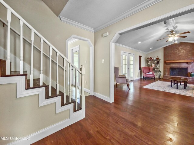 entryway featuring wood finished floors, lofted ceiling, baseboards, ceiling fan, and arched walkways