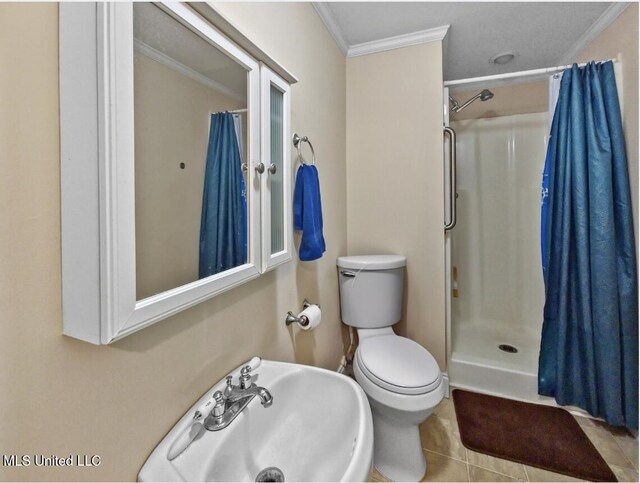 full bathroom with crown molding, tile patterned flooring, toilet, a shower with curtain, and a sink