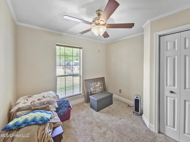 sitting room with baseboards, ornamental molding, carpet, and ceiling fan
