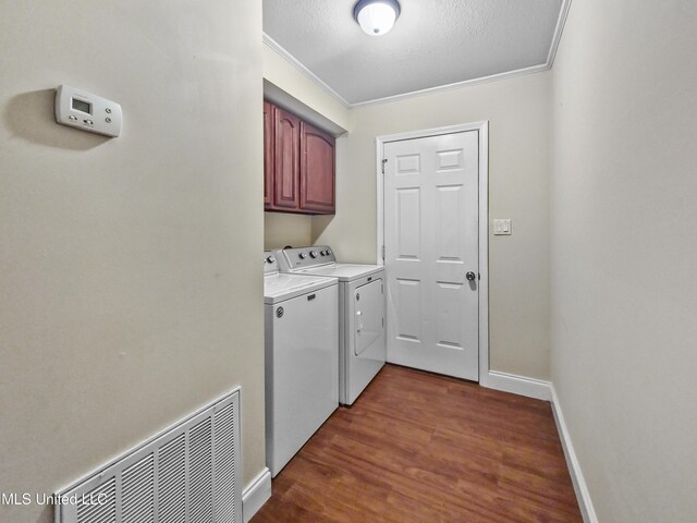 laundry area featuring visible vents, ornamental molding, washer and dryer, dark wood finished floors, and cabinet space