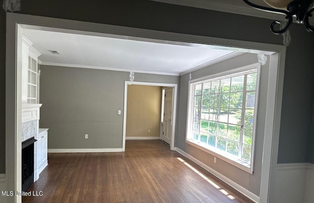 unfurnished living room with crown molding and dark wood-type flooring