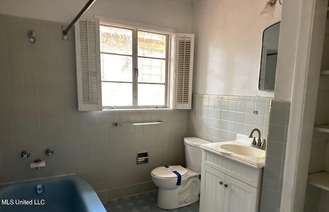 full bathroom featuring toilet, tiled shower / bath, vanity, and tile walls