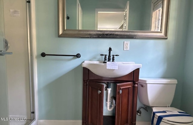 bathroom featuring vanity, toilet, and walk in shower