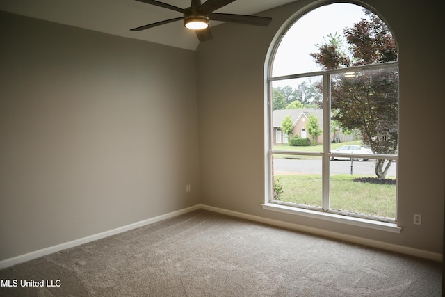 unfurnished room featuring carpet, a ceiling fan, and baseboards