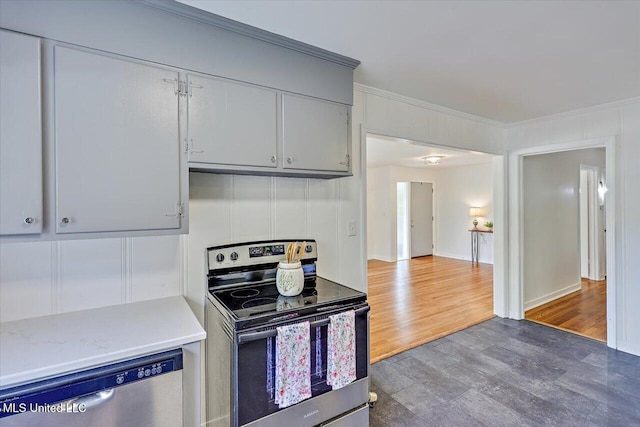 kitchen with gray cabinetry, ornamental molding, stainless steel appliances, and wood-type flooring