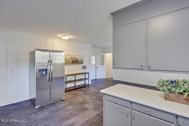 kitchen with stainless steel refrigerator with ice dispenser, dark hardwood / wood-style floors, and gray cabinets