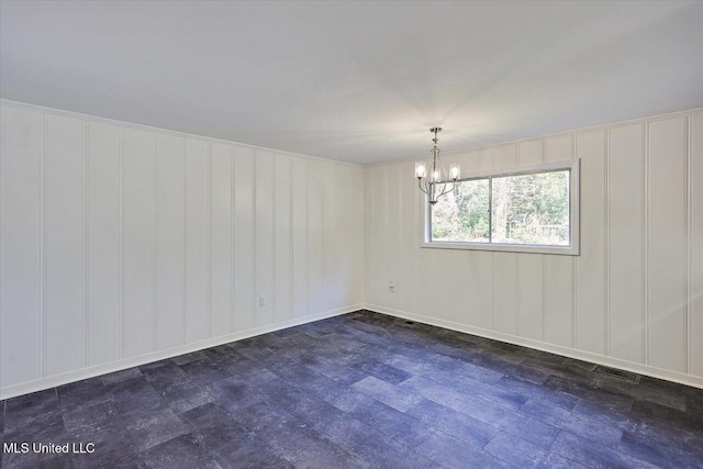 spare room featuring a chandelier