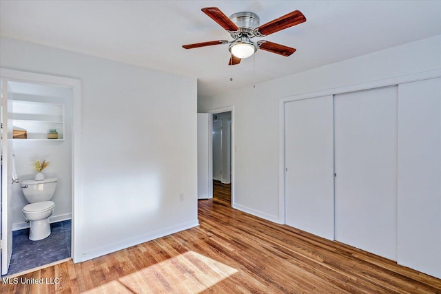 unfurnished bedroom with ensuite bathroom, a closet, ceiling fan, and light hardwood / wood-style flooring