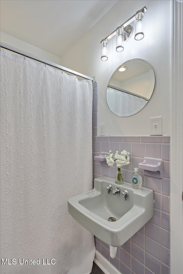 bathroom featuring tile walls and sink