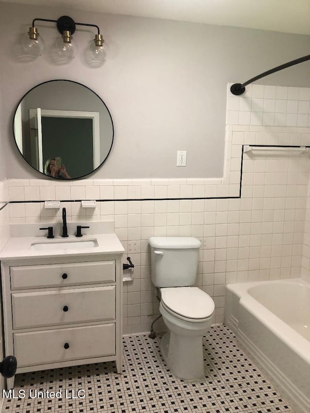 214 Evelyn St, Senatobia, MS 38668 - full bathroom with tile walls, vanity, toilet, tile patterned floors, and wainscoting