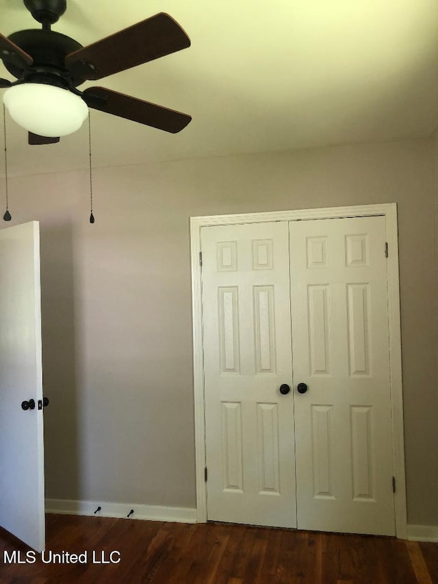 214 Evelyn St, Senatobia, MS 38668 - unfurnished bedroom with dark wood finished floors, a closet, baseboards, and ceiling fan
