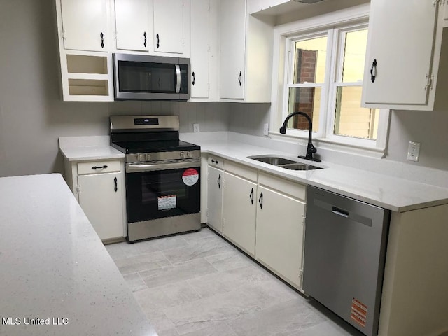 214 Evelyn St, Senatobia, MS 38668 - kitchen with stainless steel appliances, a sink, light countertops, and white cabinets