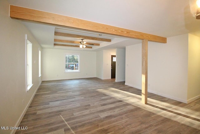 spare room featuring hardwood / wood-style flooring, ceiling fan, and beam ceiling