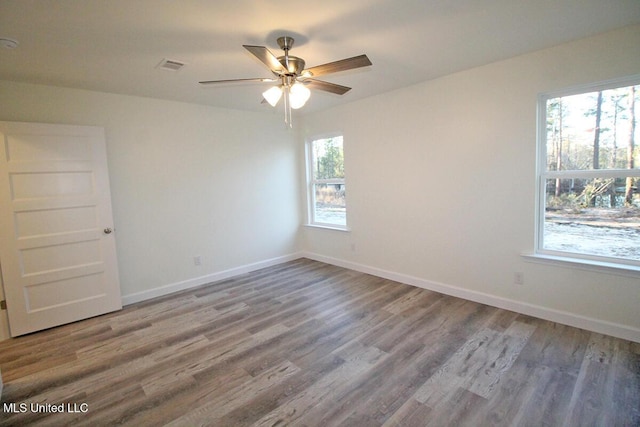 empty room featuring hardwood / wood-style floors, plenty of natural light, and ceiling fan